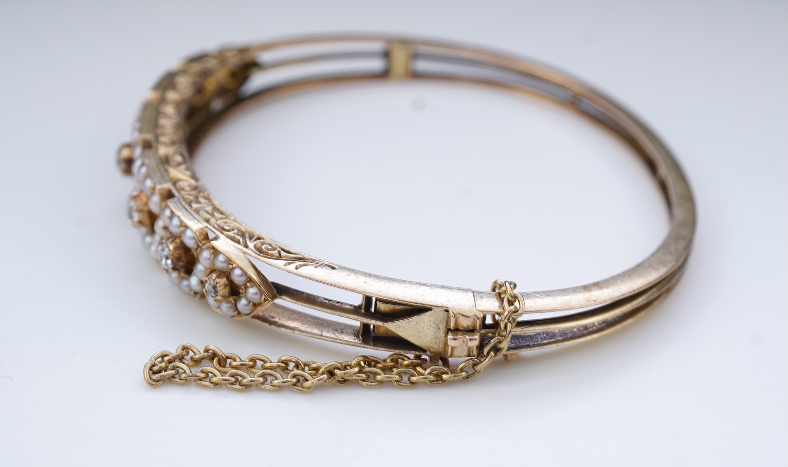 An Edwardian seed pearl and diamond bangle, early 20th century